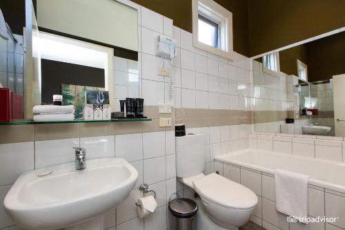 Tolarno Hotel - Mirka’s Studio - Australia في ملبورن: حمام أبيض مع حوض ومرحاض