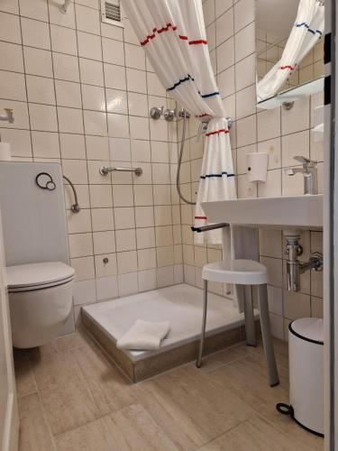 a bathroom with a shower and a sink and a toilet at Apart Hotel Freiburg in Freiburg im Breisgau
