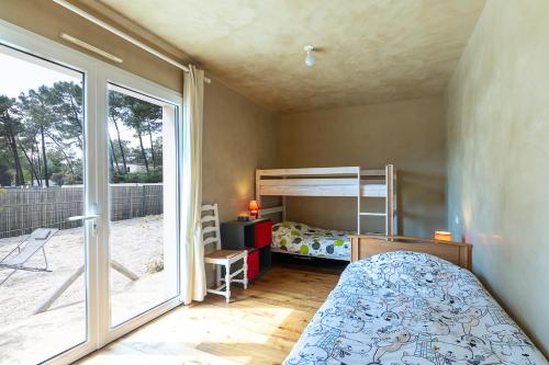 une chambre avec un lit superposé et une fenêtre dans l'établissement Maison 100m2 proche plage et forêt, à Saint-Jean-de-Monts