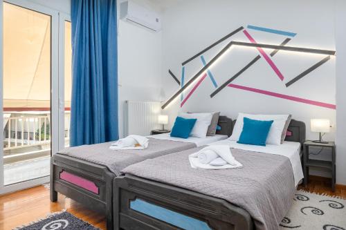 1 Schlafzimmer mit 2 Betten in blau und rosa in der Unterkunft Athenian Oasis Near Metro Station in Athen