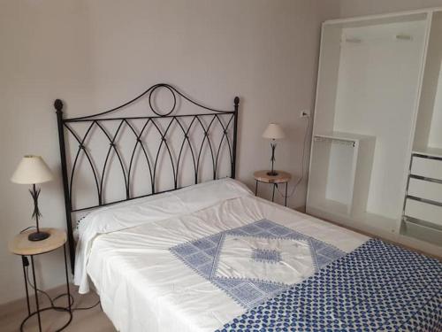 a bed in a bedroom with two tables and two lamps at ALOJAMIENTO EN CULLERa in Cullera