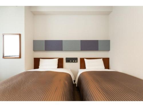 dos camas sentadas una al lado de la otra en un dormitorio en The One Five Marine Fukuoka - Vacation STAY 40107v, en Fukuoka