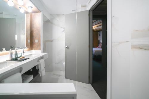 een witte badkamer met een wastafel en een spiegel bij Hotel La Pau in Barcelona