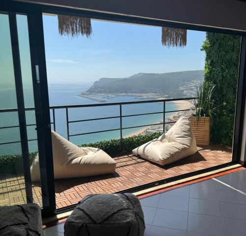 a balcony with pillows and a view of the ocean at Penthouse Ocean View Sesimbra - parking @center in Sesimbra