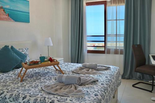 a hotel room with a bed with towels on it at Capitain Beachside Haven in Acantilado de los Gigantes
