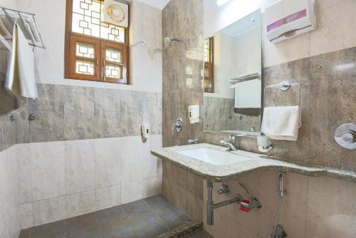 een badkamer met een wastafel en een spiegel bij BedChambers Service Apartment, South City 1 in Gurgaon