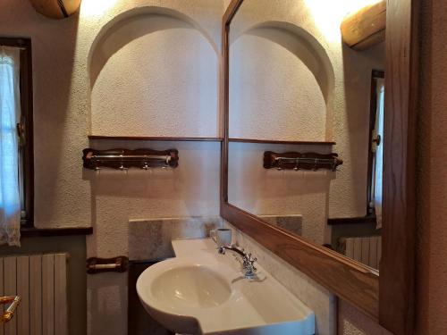 een badkamer met een wastafel en een spiegel bij Tabia Maredane in Falcade