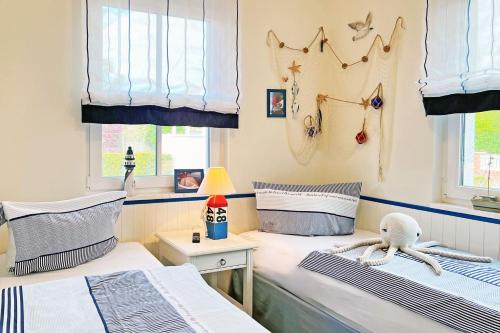 - 2 lits jumeaux dans une chambre avec des rideaux bleus dans l'établissement Käptn ADI, à Groß Kirr