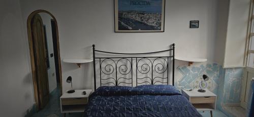 プローチダにあるPiccolo Tirreno Hotel Residenceのベッドルーム1室(青いベッド1台、ナイトスタンド2台付)