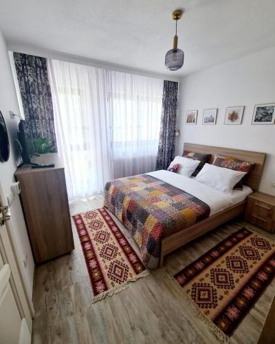 a bedroom with a large bed and a rug at Apartament Eminescu 2 in Zărneşti