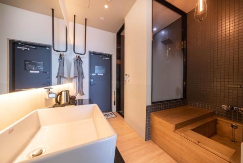 a bathroom with a white sink and a shower at H Avenue Hotel Gwangalli branch in Busan