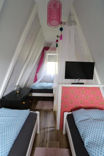 a attic bedroom with two beds and a tv at Ferienhaus nähe Warnemünde in Elmenhorst