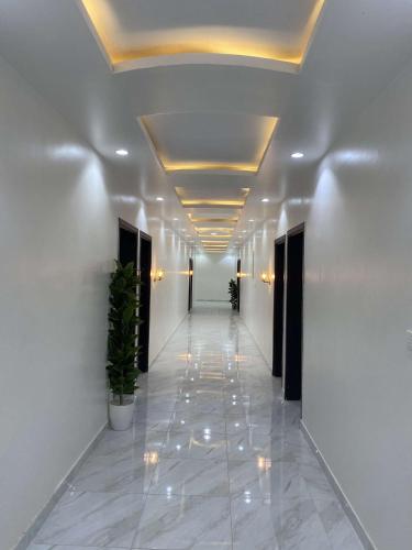 korytarz z białymi ścianami i sufitem z oświetleniem w obiekcie NEW City w mieście Al Bad‘