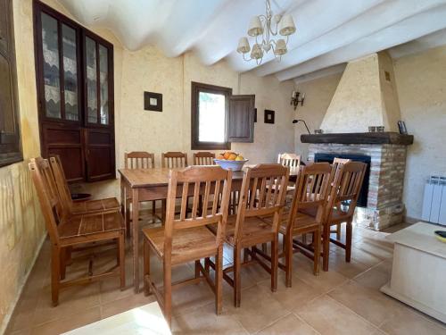 a dining room with a table and chairs and a fireplace at Casas Amarillas. Finca el Campillo in Blanca