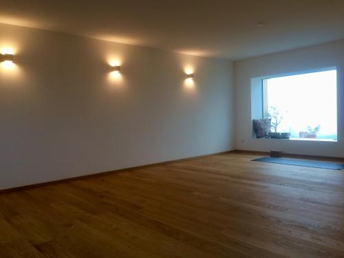 an empty room with a large window and wooden floors at Die Mansarde in Spielfeld