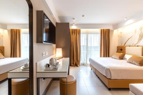a hotel room with two beds and a tv at Hotel Feldberg in Riccione