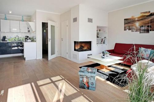 un soggiorno con divano rosso e una cucina di Ocean Star a Zingst