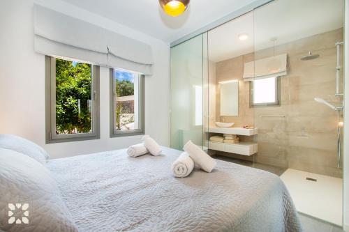 ベニッサにあるVilla El Palmeral by Abahana Villasのベッドルーム1室(白いベッド1台、タオル2枚付)