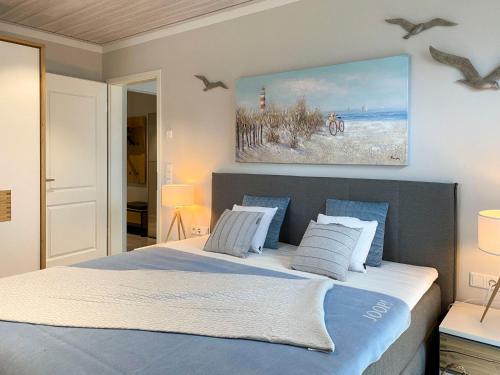 ein Schlafzimmer mit einem großen Bett mit Vögeln an der Wand in der Unterkunft PanoramaLiebe, Apartment 21 in Wustrow