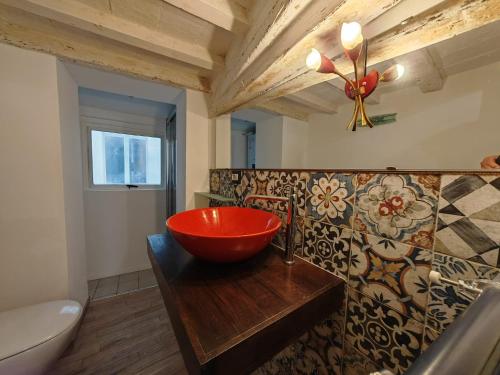 uma casa de banho com uma tigela vermelha num balcão de madeira em Jolie Maison au coeur de Parma Parking privé gratuit em Parma