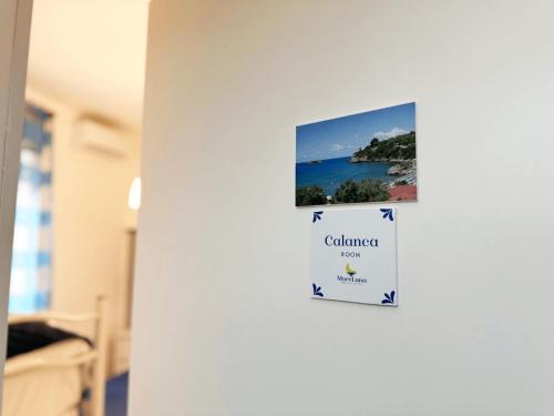 eine weiße Wand mit einem Bild des Ozeans in der Unterkunft Mareluna Bed and Breakfast in Marina di Camerota
