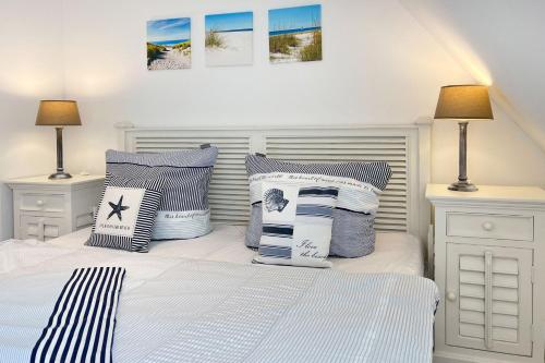 een slaapkamer met een bed met blauwe en witte kussens bij Strandhaus Zingst in Zingst
