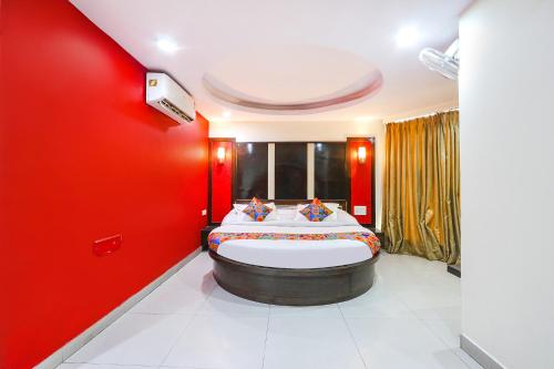 1 dormitorio con 1 cama grande y paredes rojas en FabHotel Royal Residency II, en Hyderabad