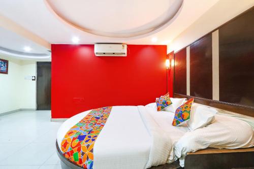 sypialnia z dużym łóżkiem z czerwoną ścianą w obiekcie FabHotel Royal Residency II w mieście Hajdarabad