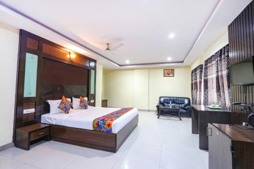 a bedroom with a bed and a chair in a room at FabHotel Royal Residency II - Nr Lakdikapul Metro Station in Hyderabad