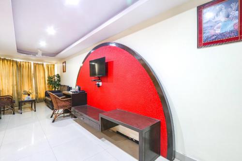 a red wall with a bench in a room at FabHotel Royal Residency II - Nr Lakdikapul Metro Station in Hyderabad