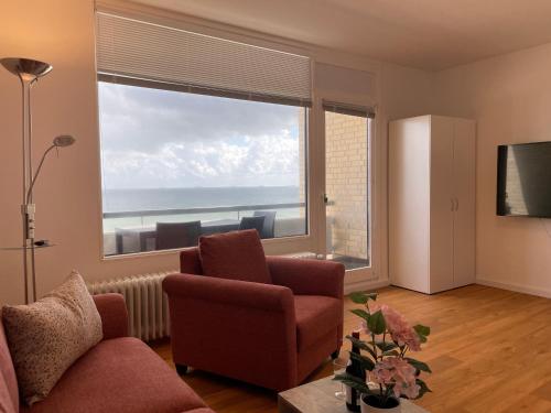 ein Wohnzimmer mit einem großen Fenster mit Meerblick in der Unterkunft Irma 28 in Wyk auf Föhr