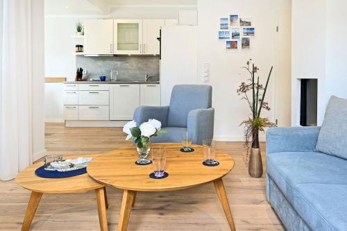 a living room with a blue couch and a table at Wellenflüstern in Zingst