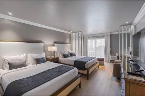 A bed or beds in a room at The Volare, Ascend Hotel Collection