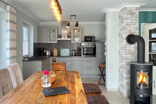 a kitchen with a wooden table and a fireplace at Windspiel in Zingst
