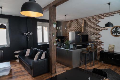 a living room with a couch and a kitchen at Le petit boulanger, grand 70 m2, garage disponible in Mulhouse