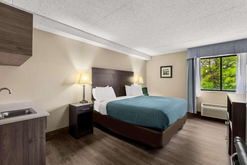 a hotel room with a bed and a sink at Suburban Studios Columbia Northwest in Columbia