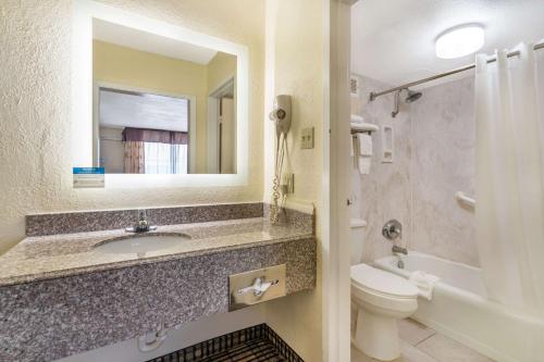 a bathroom with a sink and a toilet and a mirror at Quality Inn in Tucumcari
