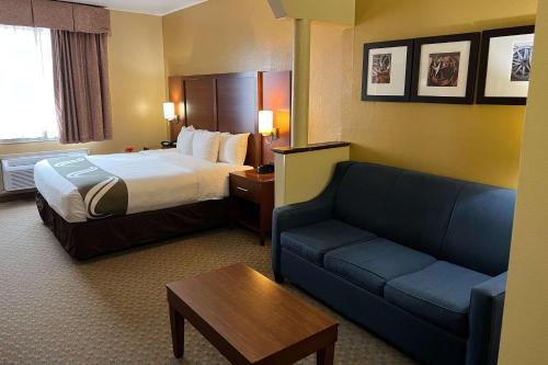 a hotel room with a bed and a couch at Quality Suites Midland North Loop 250 in Midland