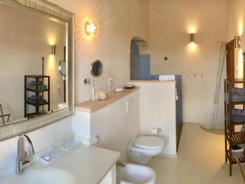 a bathroom with a toilet and a sink and a mirror at Casa 3 Leones in Llombarts