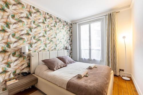 - une chambre avec un lit orné d'une fresque murale dans l'établissement GuestReady - Espace lumineux à Neuilly-sur-Seine, à Neuilly-sur-Seine