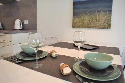 達默的住宿－FeWo Seemaus，一张桌子,上面有两杯,两个盘子和碗
