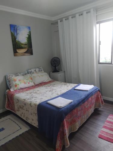 ein Schlafzimmer mit einem Bett mit zwei Handtüchern darauf in der Unterkunft Quarto com banheiro privativo in Balneário Camboriú