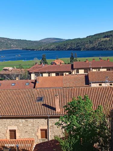 a group of buildings with red roofs and a lake at Apartamento Mirador del Pantano 1 in Vinuesa
