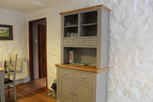 un gran armario gris en una habitación con una mesa en Ghyll Burn Cottage and Barn End Cottage, en Alston