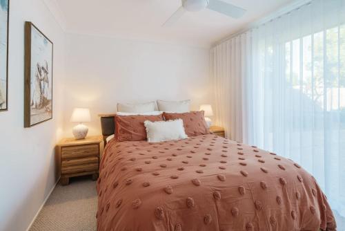 a bedroom with a large bed and a window at Battery Hill Pet-Friendly Poolside Paradise in Caloundra