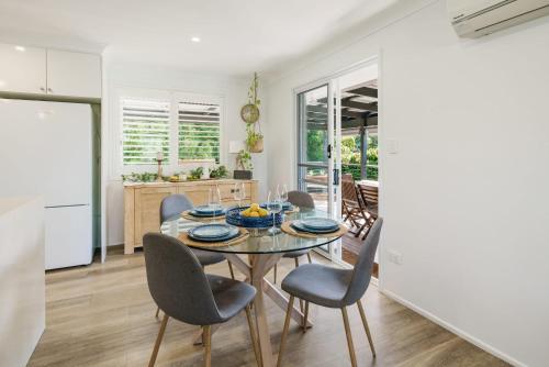 a kitchen and dining room with a table and chairs at Battery Hill Pet-Friendly Poolside Paradise in Caloundra