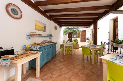 a kitchen with blue cabinets and tables and chairs at La Meridiana Hotel in San Vito lo Capo