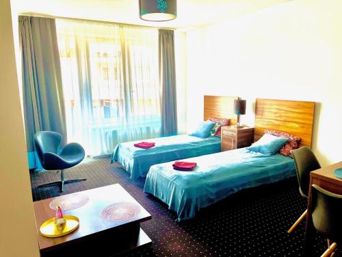 ein Hotelzimmer mit 2 Betten und einem Tisch in der Unterkunft Plage Brookforest Apartman in Hajdúszoboszló