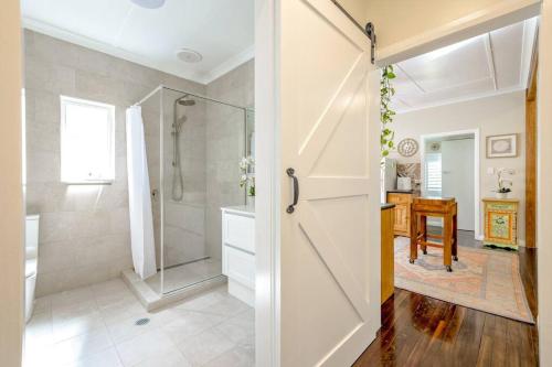 a bathroom with a shower and a glass door at Cathy's Cottage in Cairns