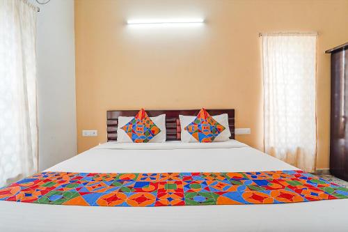 a bedroom with a bed with a colorful comforter at FabHotel S V Homestay Tirupati in Tirupati